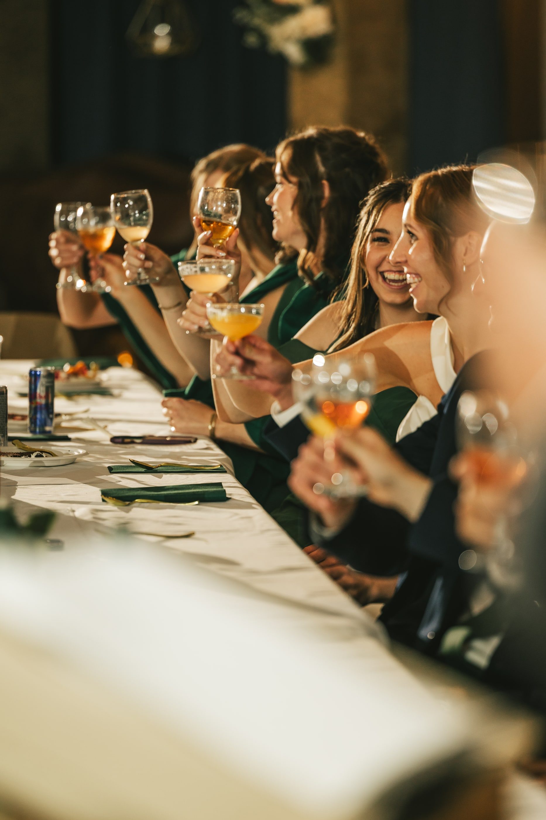 Bridesmaids raise their glasses in a toast at the head table.